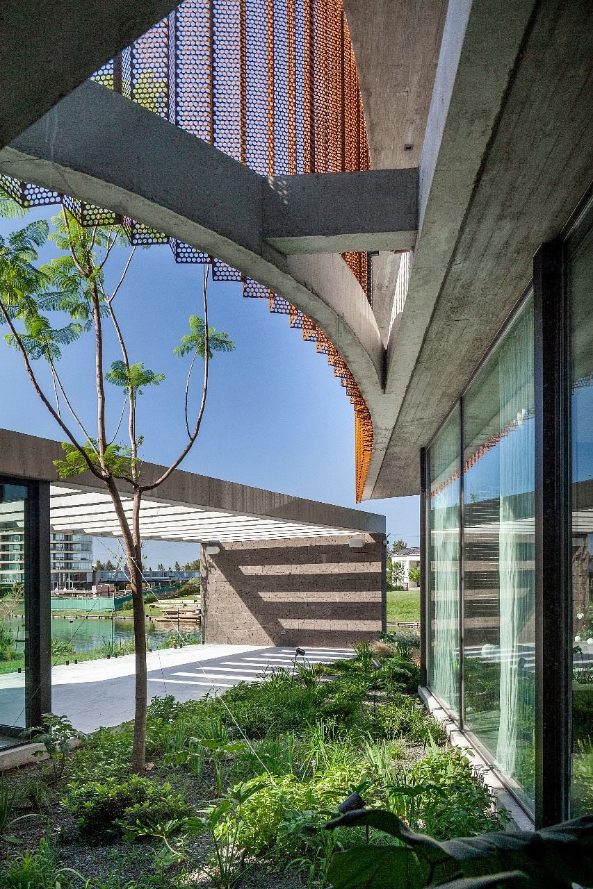 Contemporary building with curved concrete design and perforated metal detail.