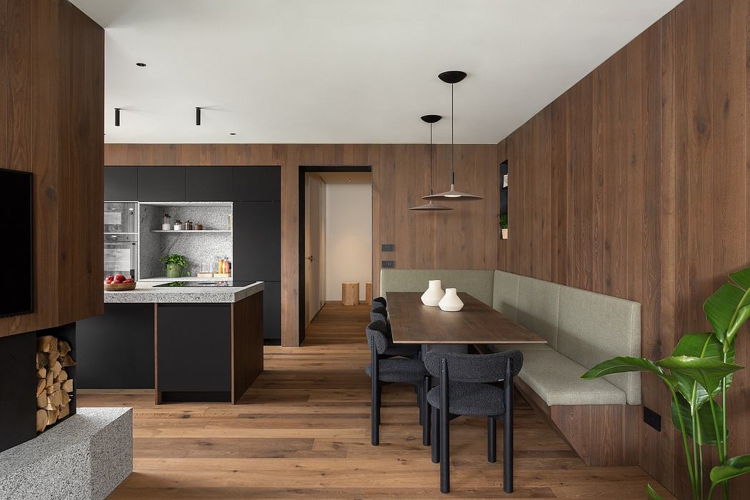 Contemporary kitchen and dining area with wood paneling and pendant lights.