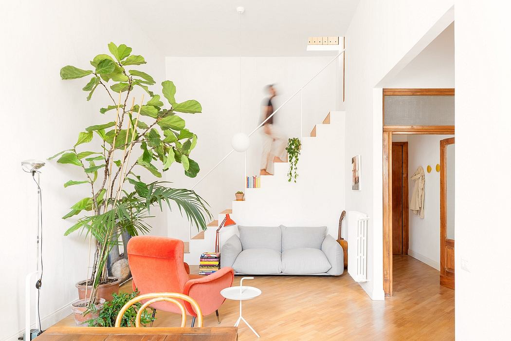 Bright living room with modern furniture and a person on stairs.