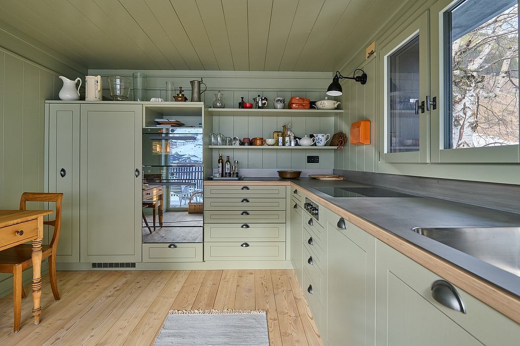 A cozy kitchen interior with sage green cabinets and wooden countertops.