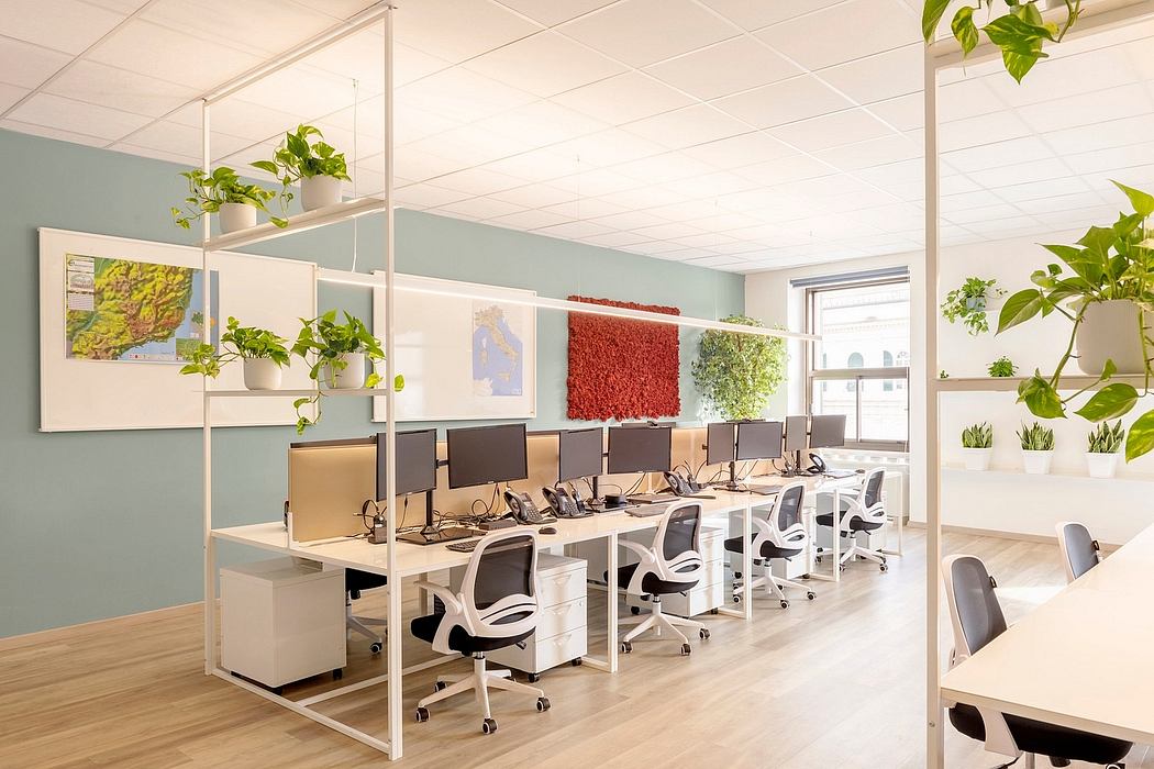 An open, well-lit office space with sleek furniture, greenery, and minimalist decor.