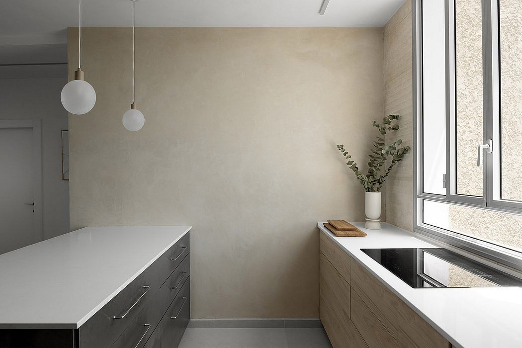 Minimalist kitchen with white countertops, pendant lights, and a window.