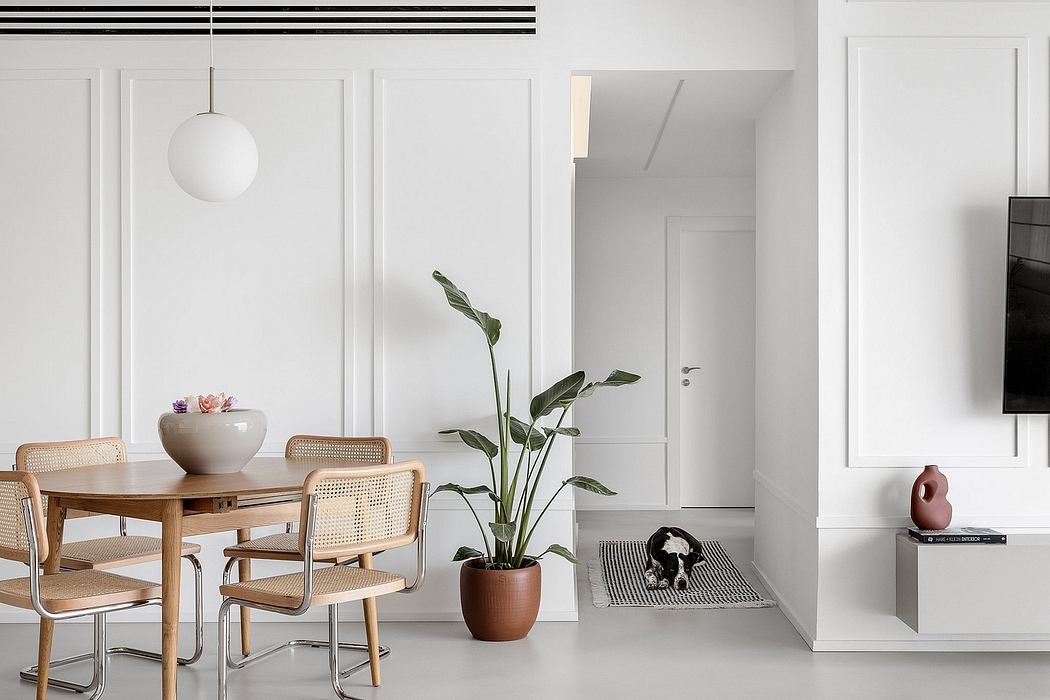 Minimalist dining room with wooden chairs and white decor.
