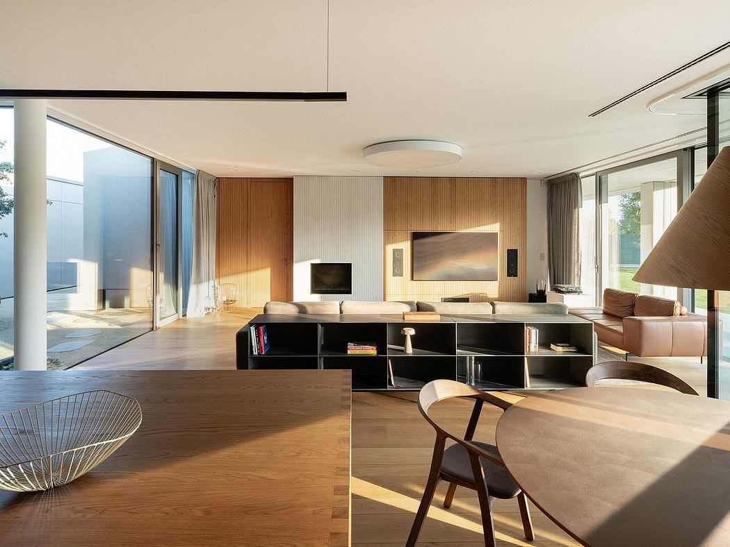 Modern living room with large windows, wooden furniture, and minimalist decor.