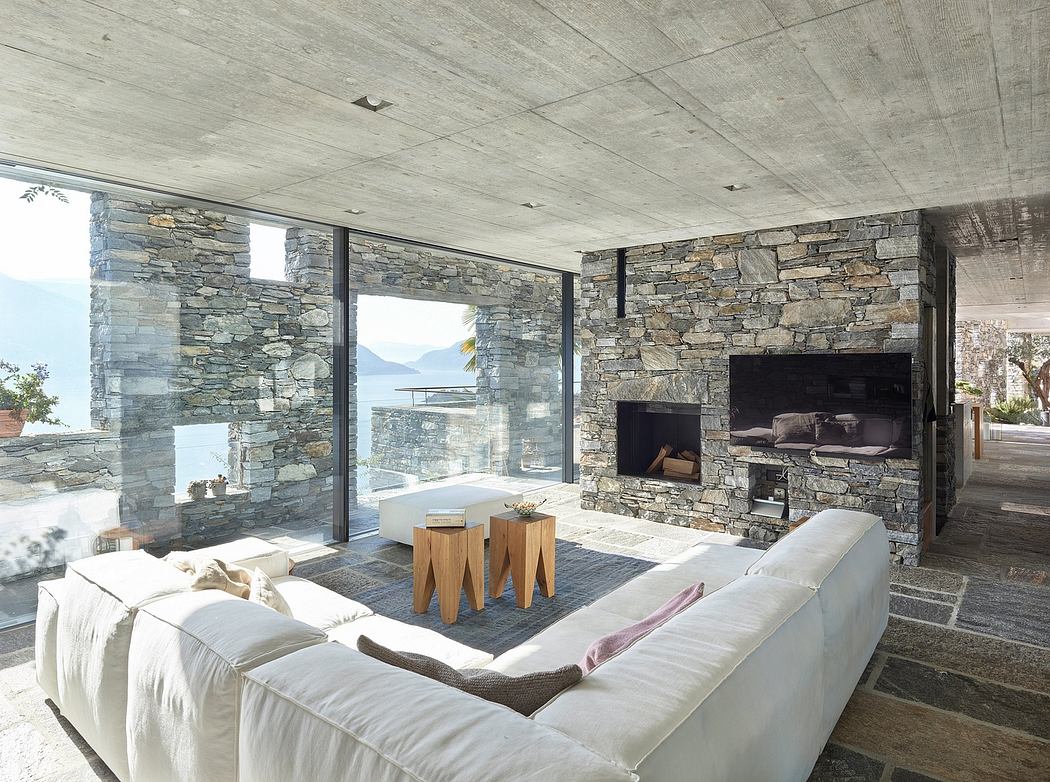 Modern living room with stone walls, a fireplace, and mountain views.
