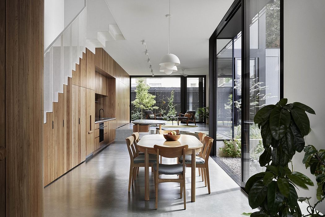 Minimalist dining space with wooden accent wall, large windows, and sculptural pendant.