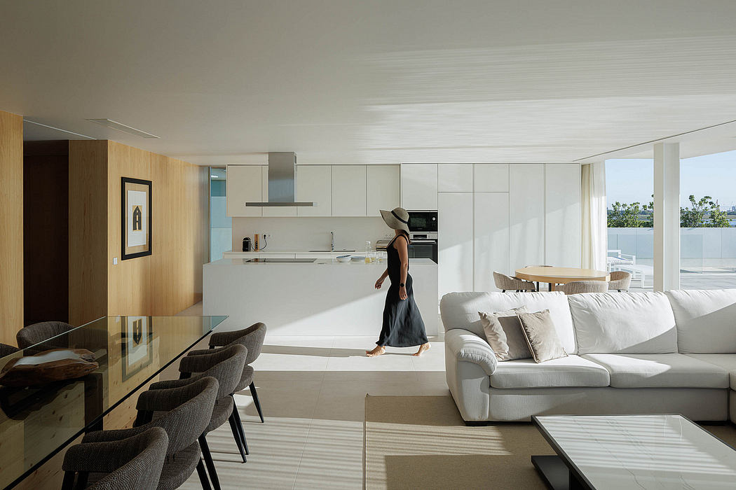 Bright, spacious open-plan living space with modern kitchen, plush seating, and floor-to-ceiling windows.