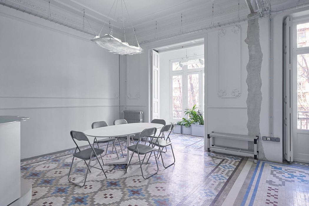 Spacious room with ornate molding, tiled floors, and a modern light fixture.