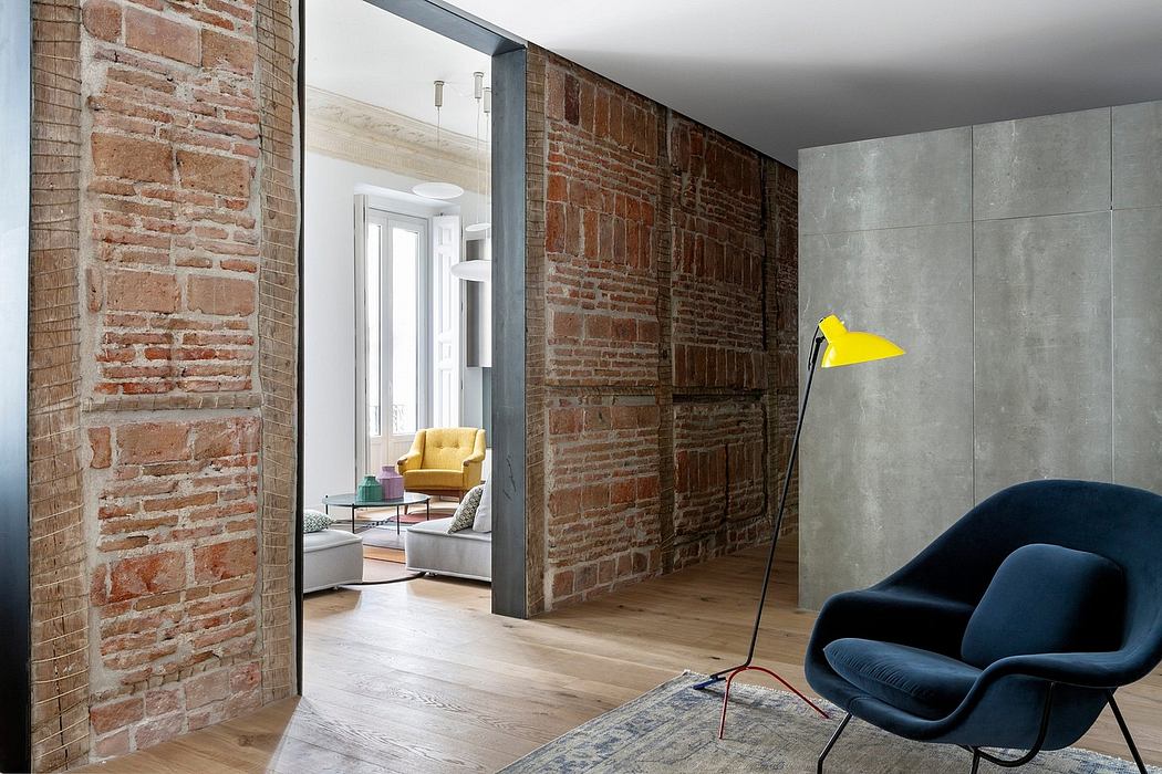 A modern living room with exposed brick walls, concrete accents, and a yellow floor lamp.