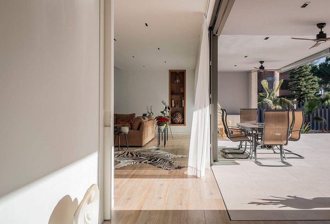 Modern indoor-outdoor living space with sliding doors, furniture, and deck.