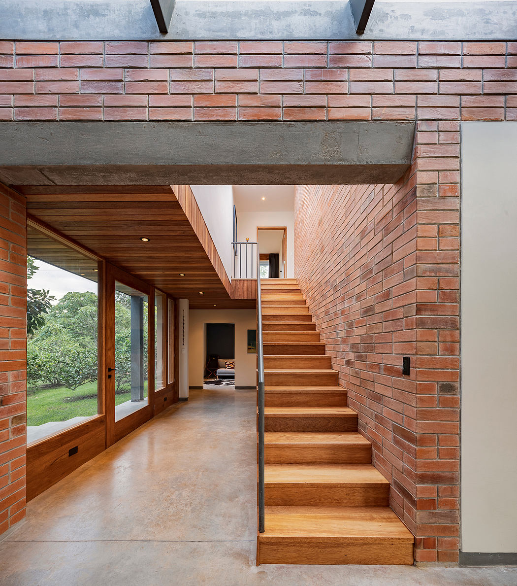 Brick walls, wood stairs, large windows, and an open, modern interior design.