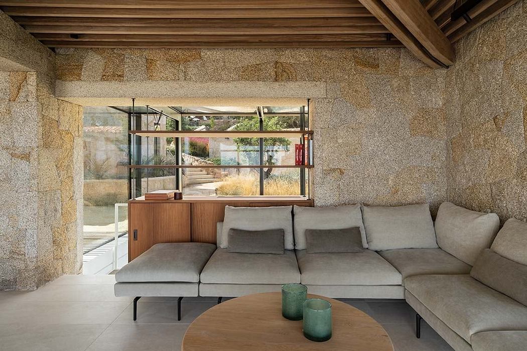 Minimalist living room with stone walls and a large window.