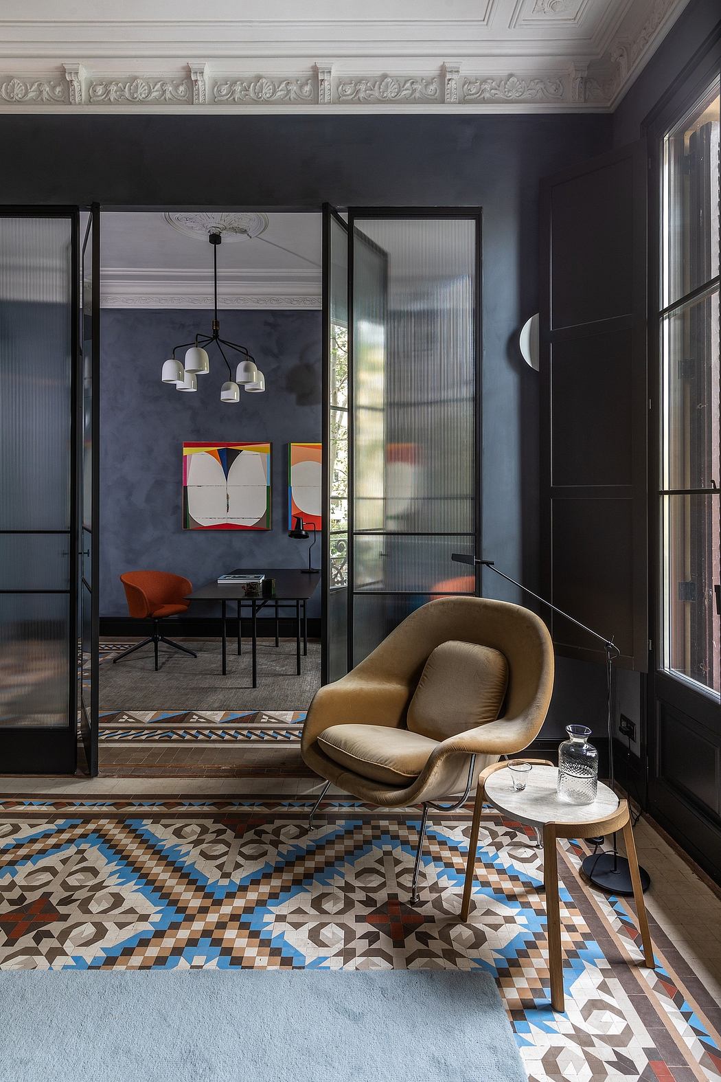 Chic interior with eclectic decor, retro chair, patterned rug, and glass