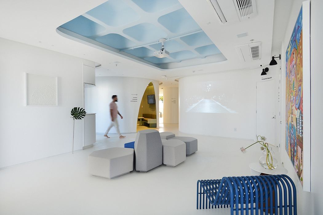 A modern, minimalist interior design with a striking, cloud-patterned ceiling and vibrant artwork.