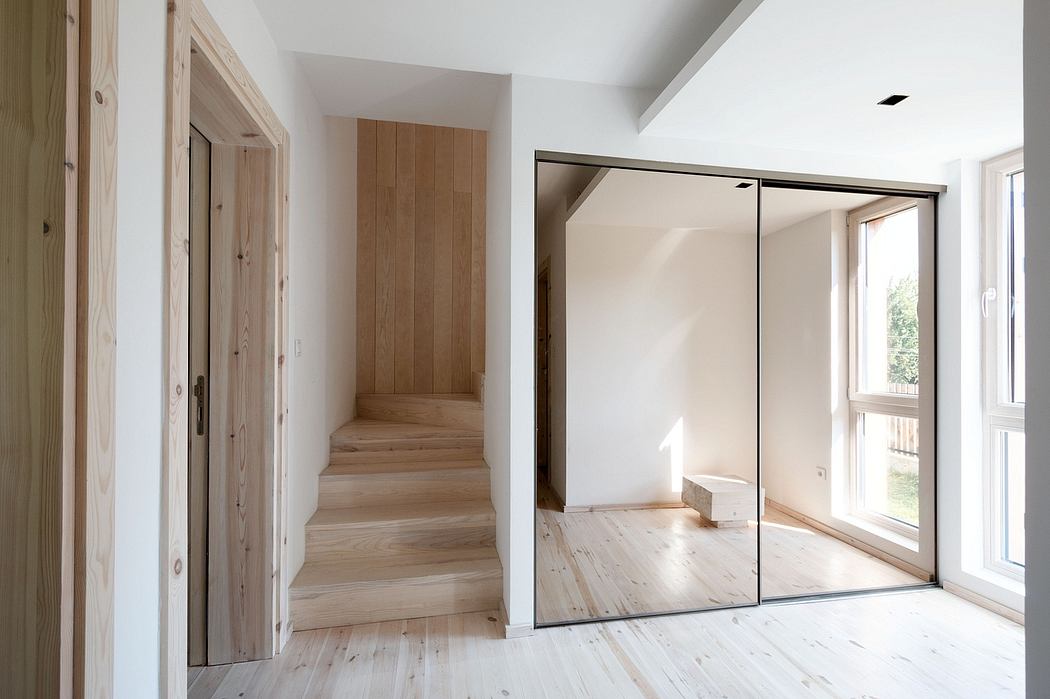 Bright, modern room with wooden stairs, mirrored closets, and natural light.