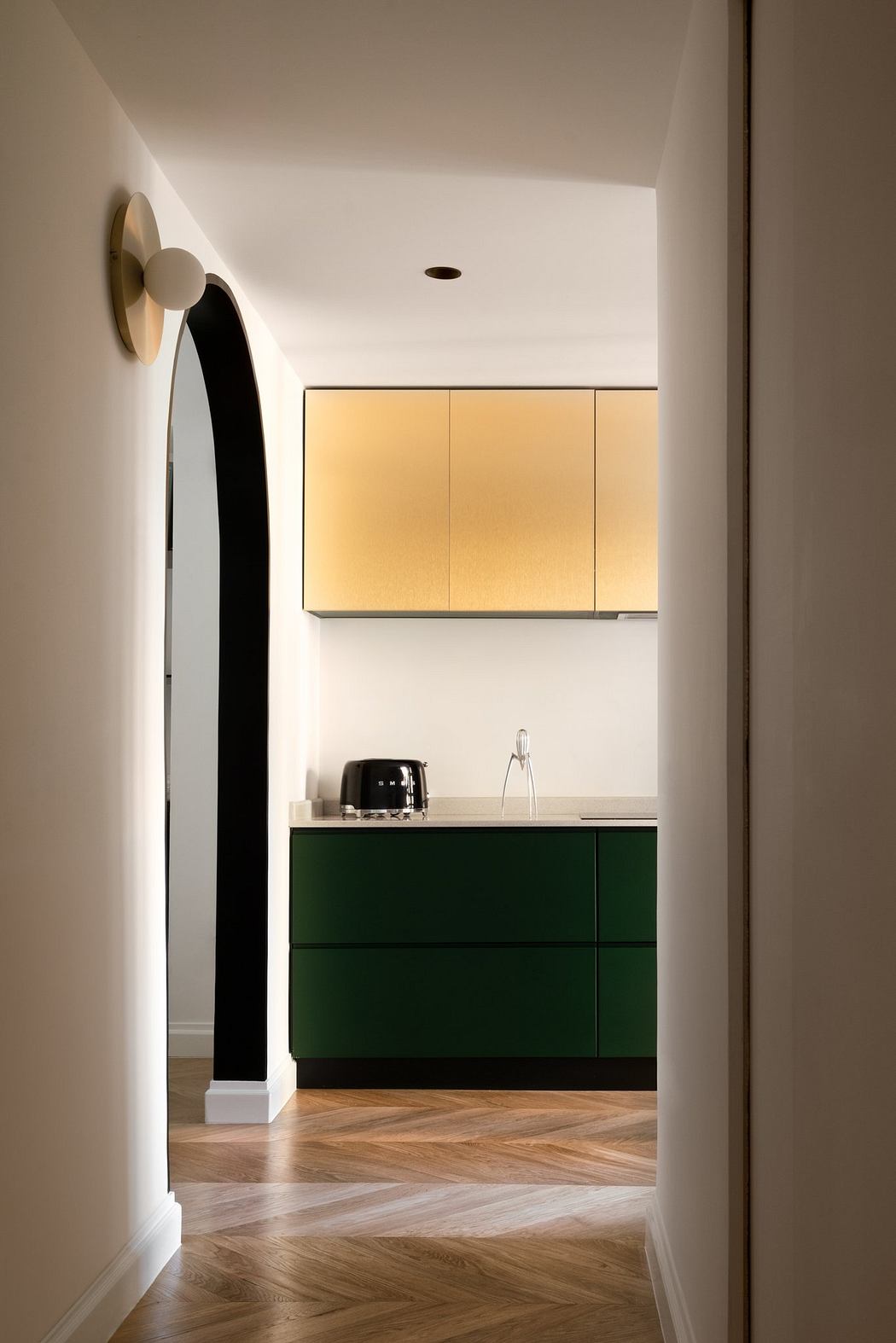 Contemporary kitchen with green cabinets and an arched doorway.
