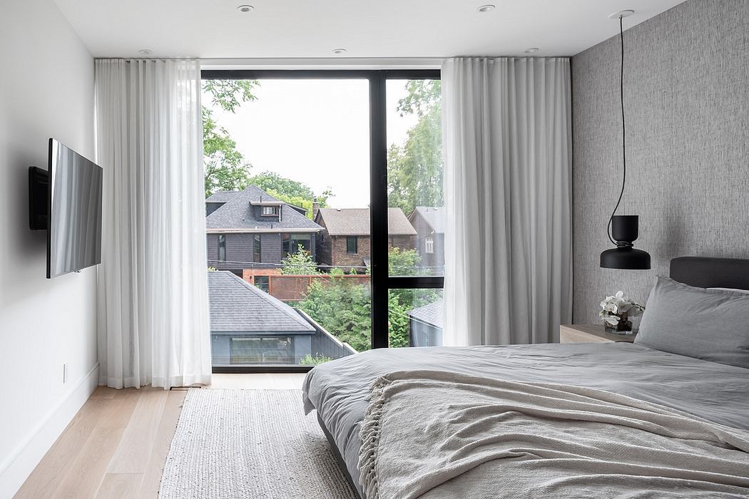 Minimalist bedroom with large window, neutral tones, and simple decor.