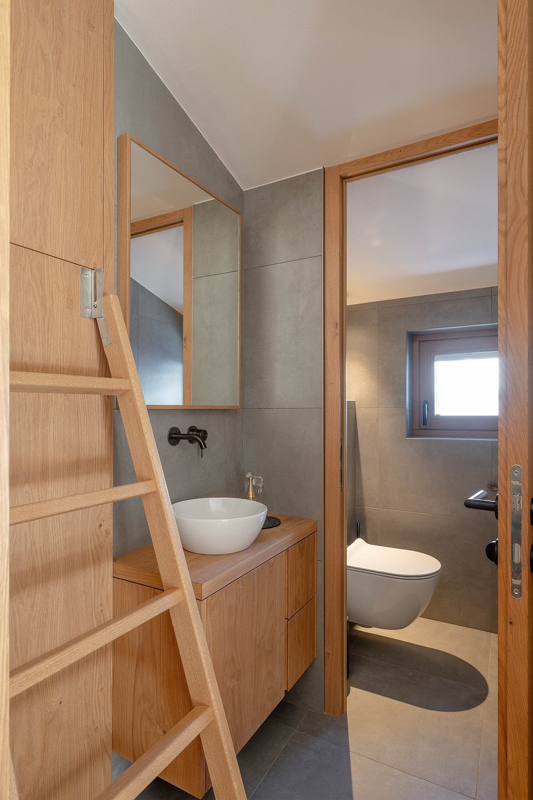 Minimalist bathroom with wood accents, vessel sink, and ladder-style shelving.