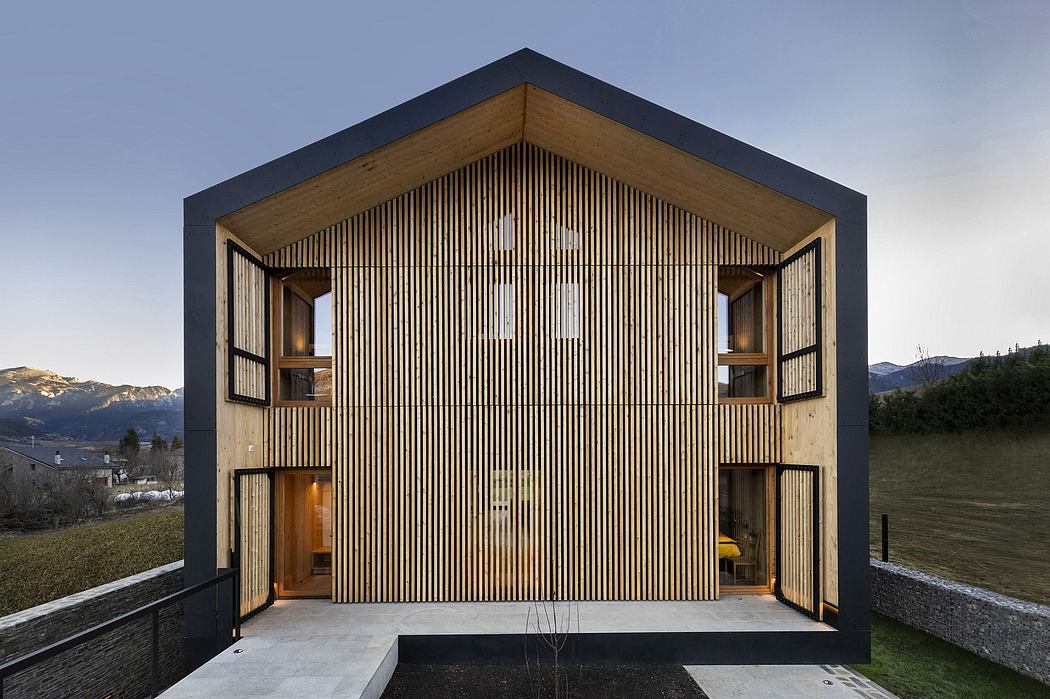 A modern, wooden and black facade with vertical and horizontal slats, surrounded by a grassy field.