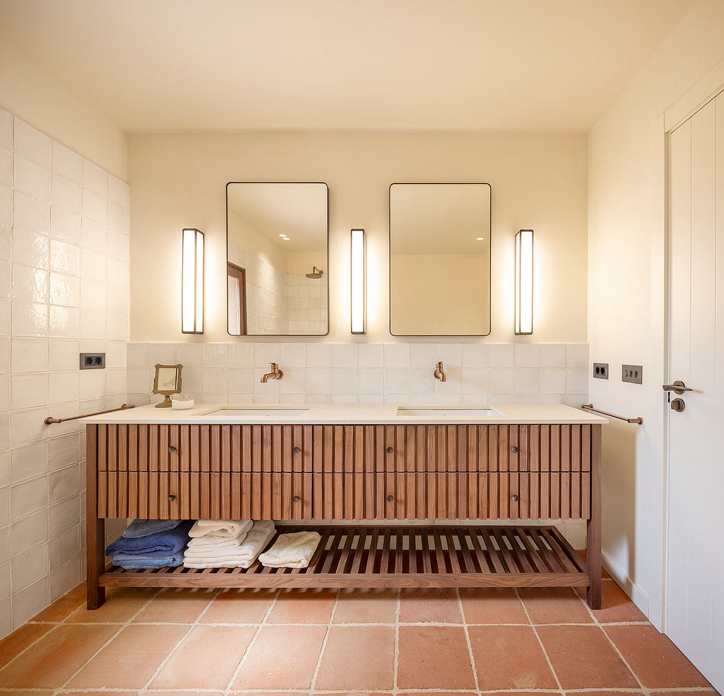Spacious bathroom with wooden vanity, double sinks, wall mirrors, and recessed lighting.