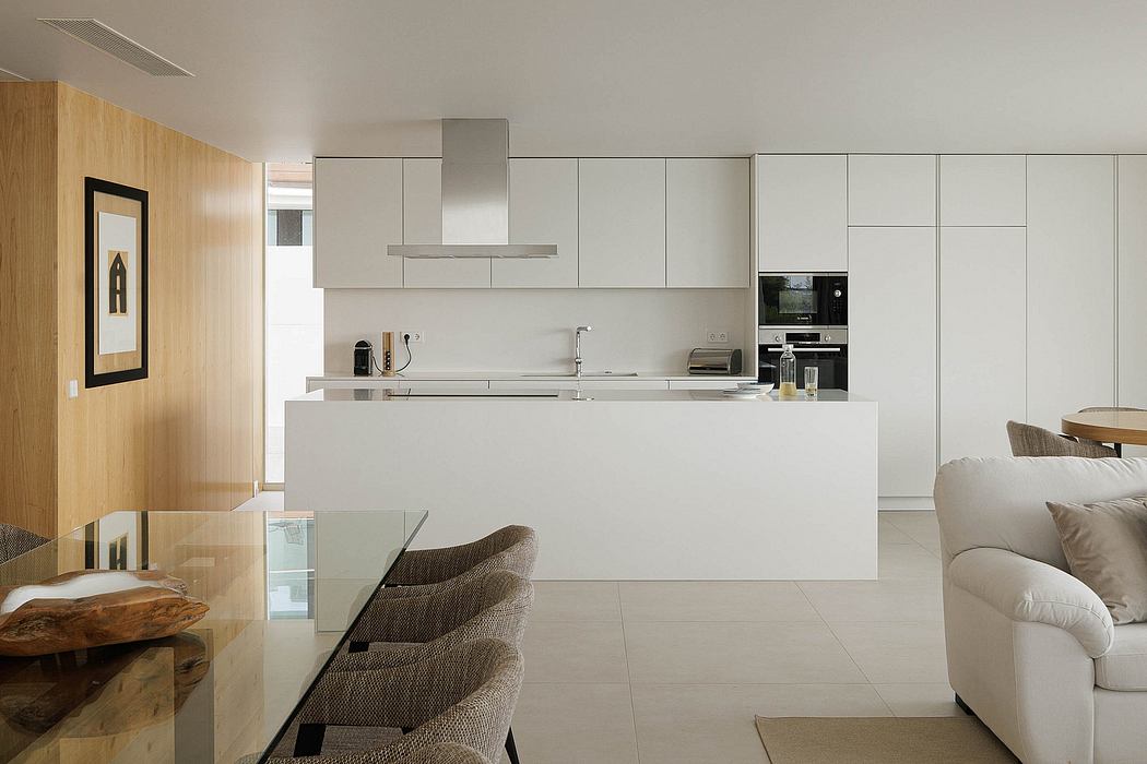 Modern kitchen with sleek white cabinetry, integrated appliances, and minimalist design.