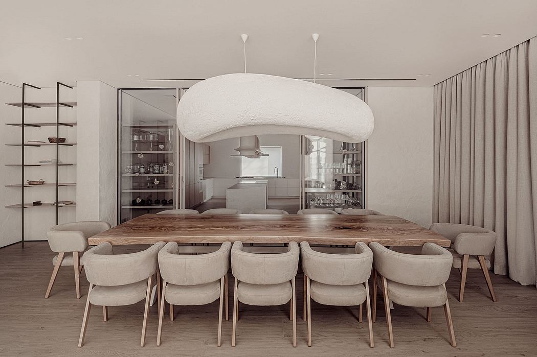 A modern, minimalist dining room with a large wooden table, plush chairs, and a striking pendant light.