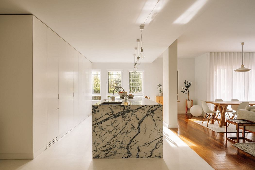 Spacious modern kitchen with large marble island and open-concept living area.