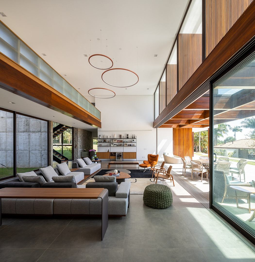 Modern living room with high ceiling, large windows, and stylish furniture.