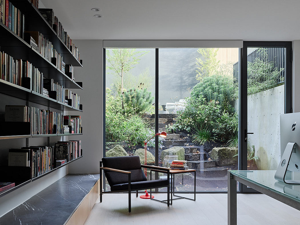 Modern home office with a bookshelf, desk, and view of a garden through