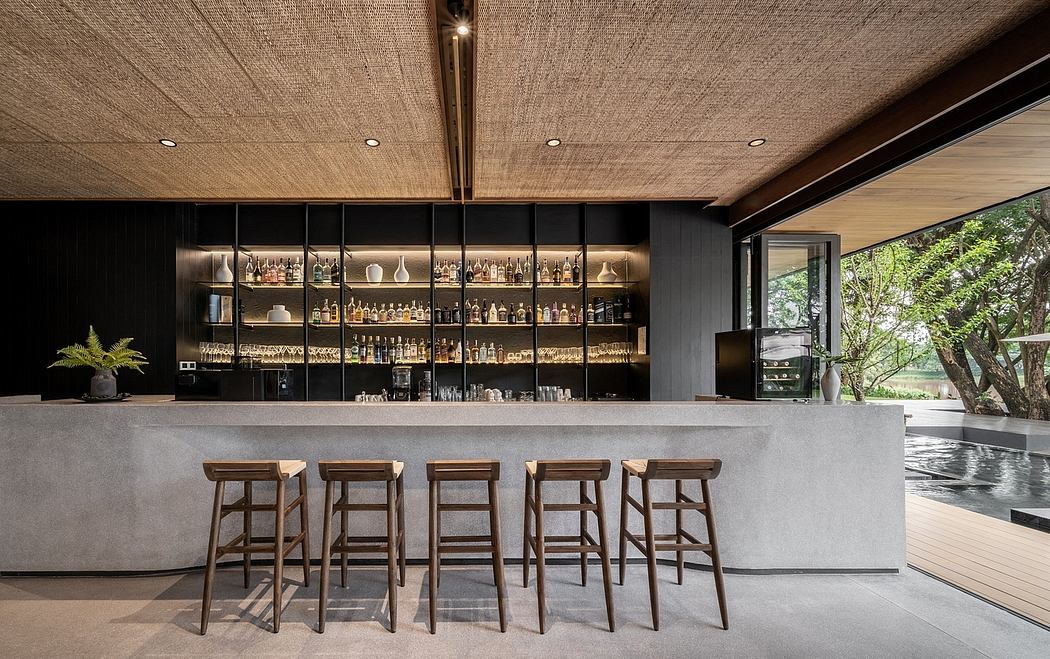 Elegant bar with textured ceiling, concrete counter, and wooden stools.