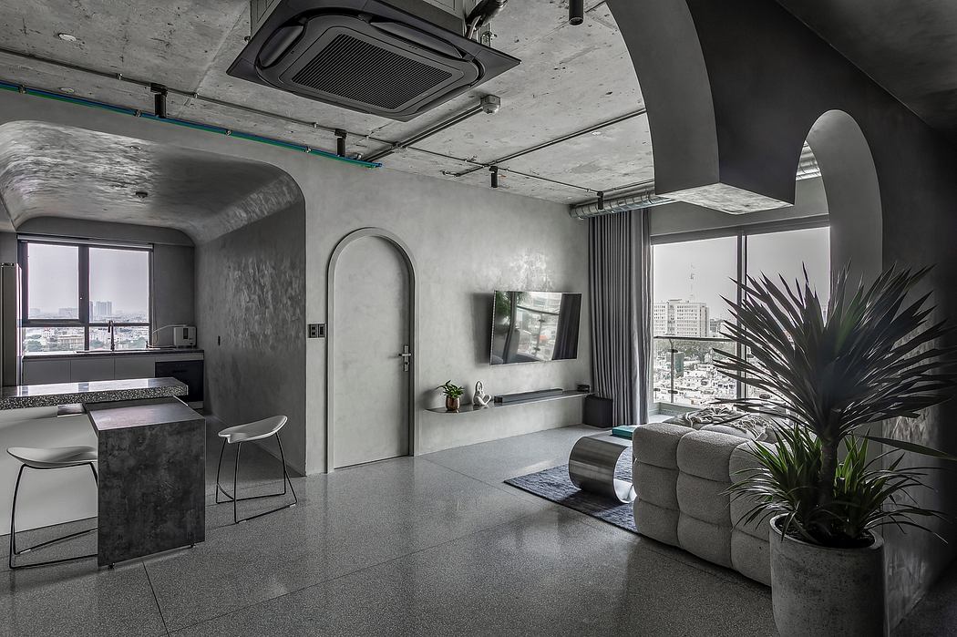 A modern, industrial-inspired interior with concrete walls, arched doorways, and a sleek kitchenette.