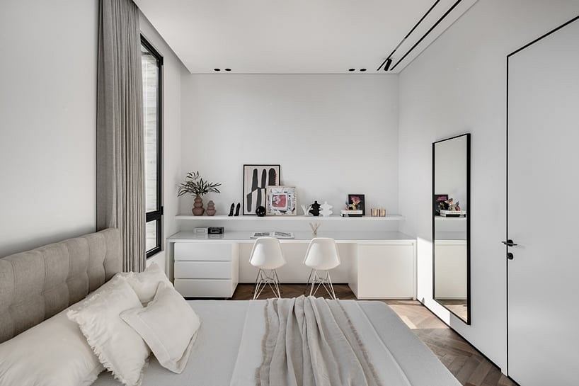 Minimalist bedroom with sleek built-in desk and stylish decor accents on shelves.