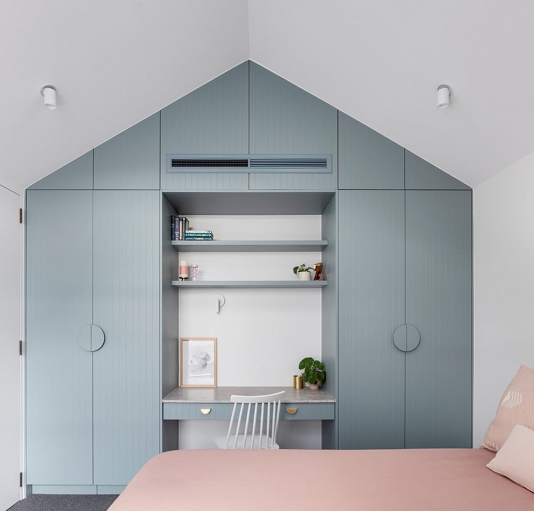 Sleek gray built-in shelves, desk, and storage unit with minimalist decor in bedroom.