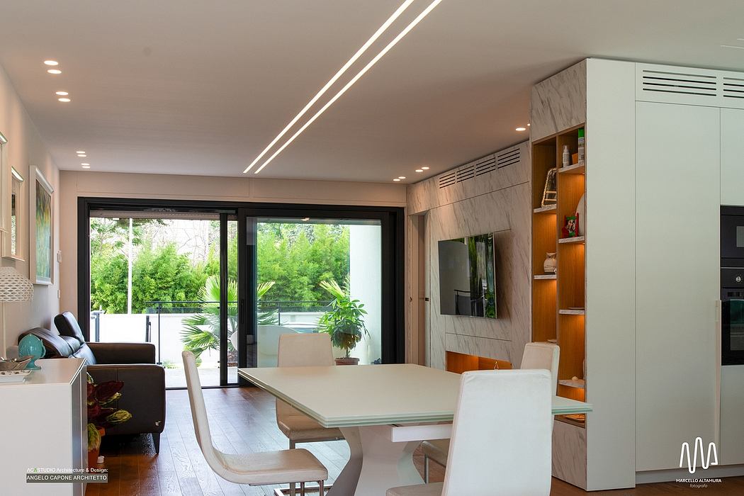 Modern open-concept living space with glass doors leading to lush outdoor greenery.
