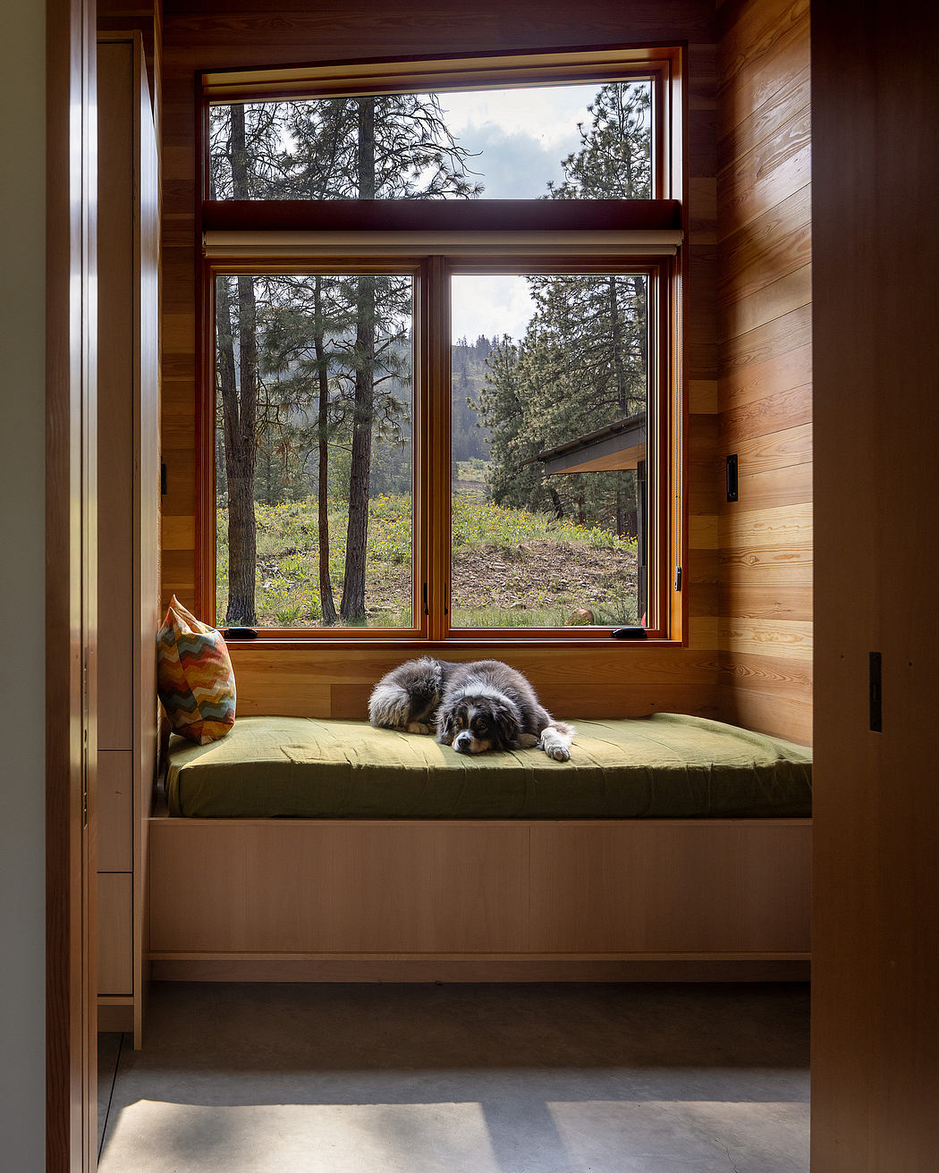 Cozy nook with a daybed, large window, and a sleeping dog