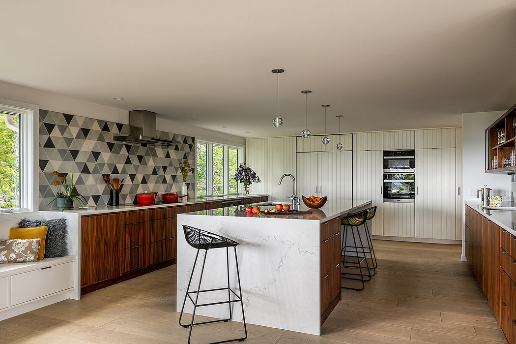 Stylish mid-century modern kitchen with geometric tile backsplash, marble island, and pendant lighting.