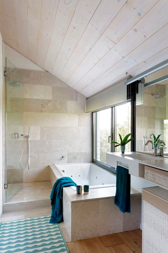 Bright bathroom with wooden ceiling and tiled walls.