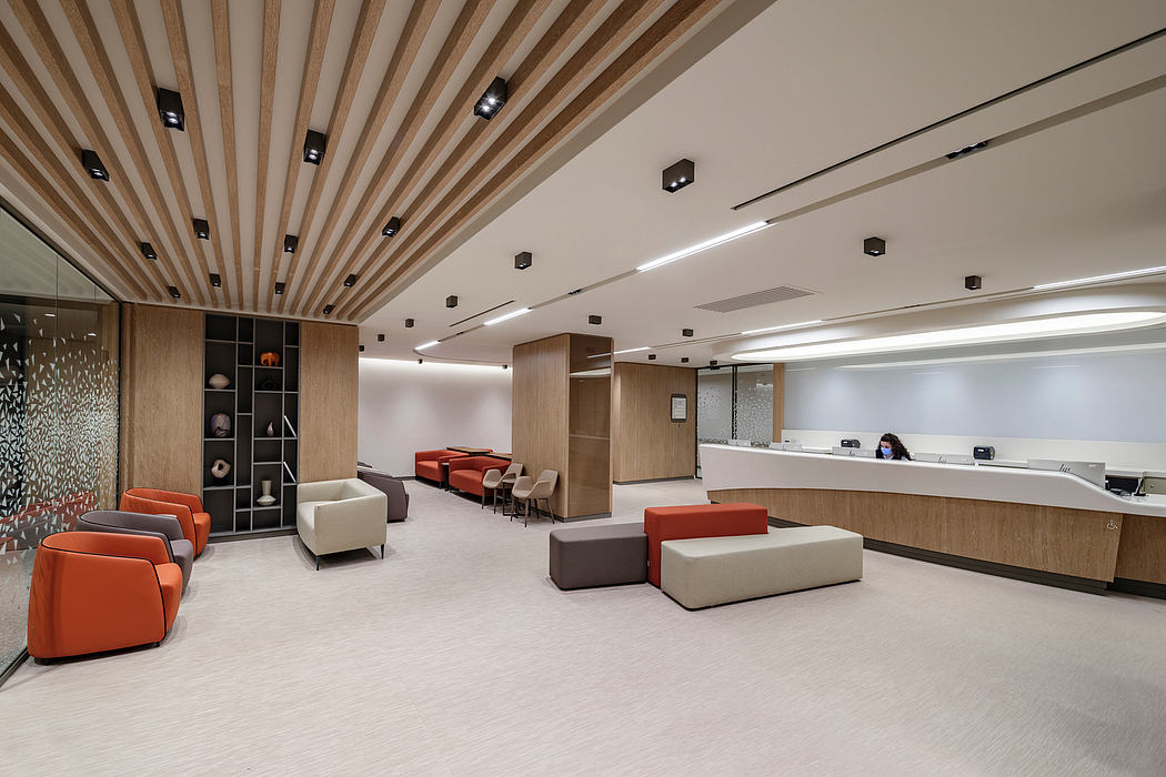 Contemporary office lobby with wooden slat ceiling and colorful seating.