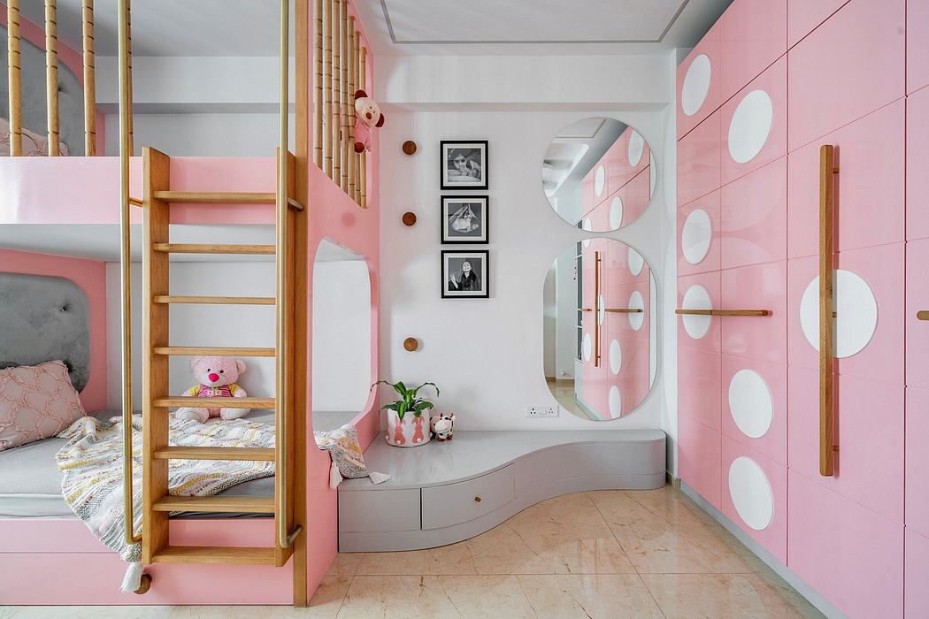 Pink-themed bedroom with bunk bed, polka dot wall, and round mirrors.