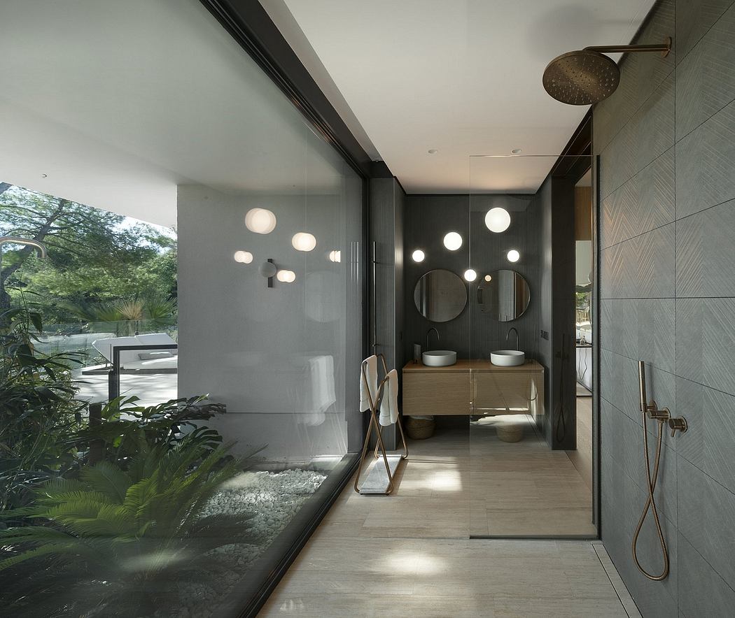 A modern, minimalist bathroom with sleek vanity, round mirrors, and hanging plants.
