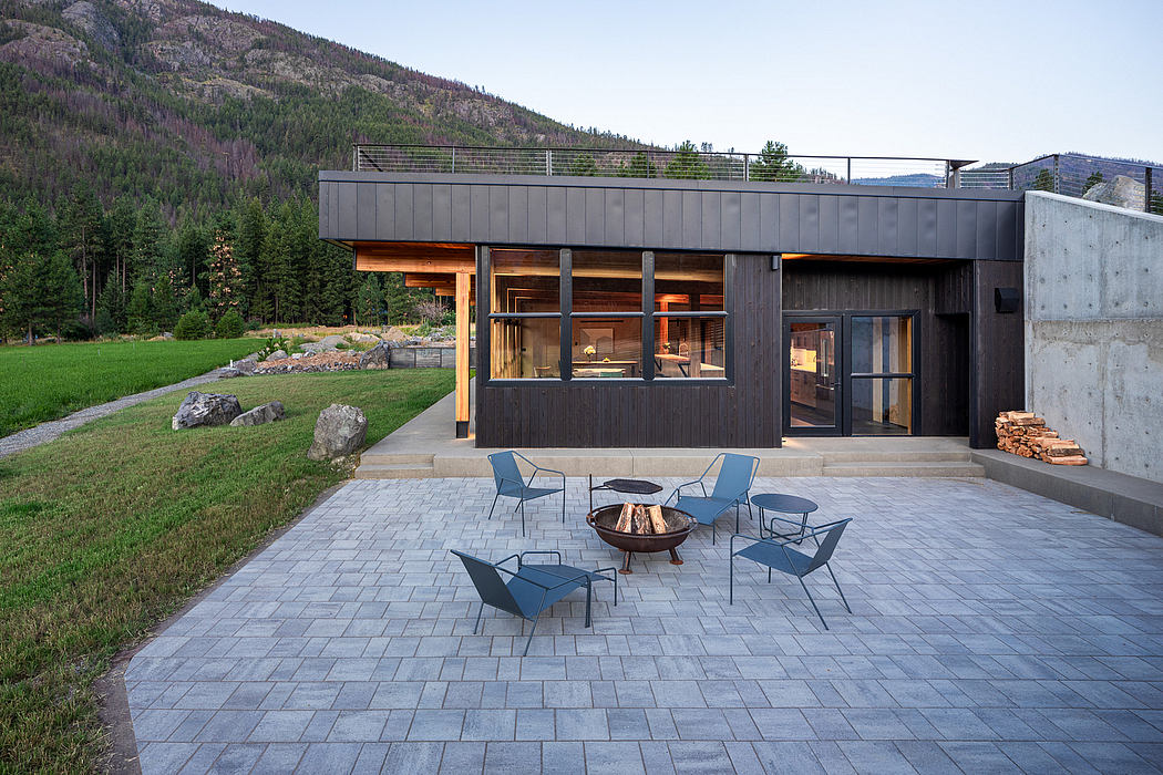 Modern mountain home with sleek exterior, wooden accents, and outdoor seating area.