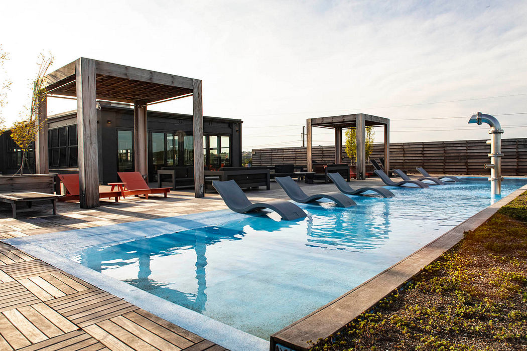 Sleek, modern pool deck with wooden cabana structures and loungers overlooking the pool.