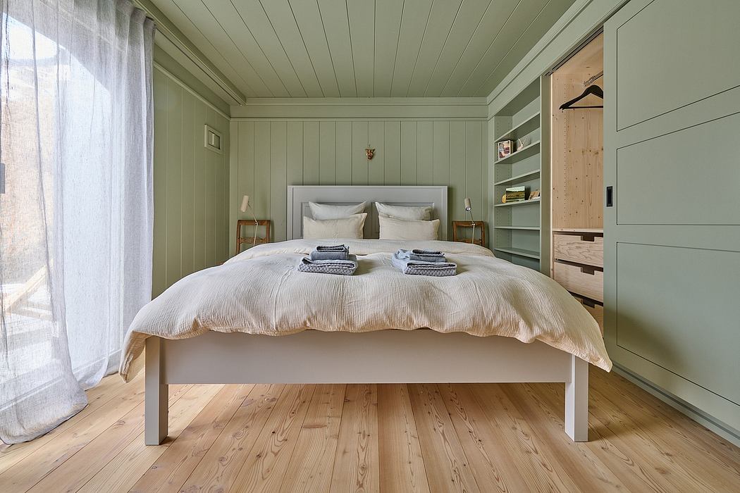 Cozy minimalist bedroom with wooden floors and green walls.