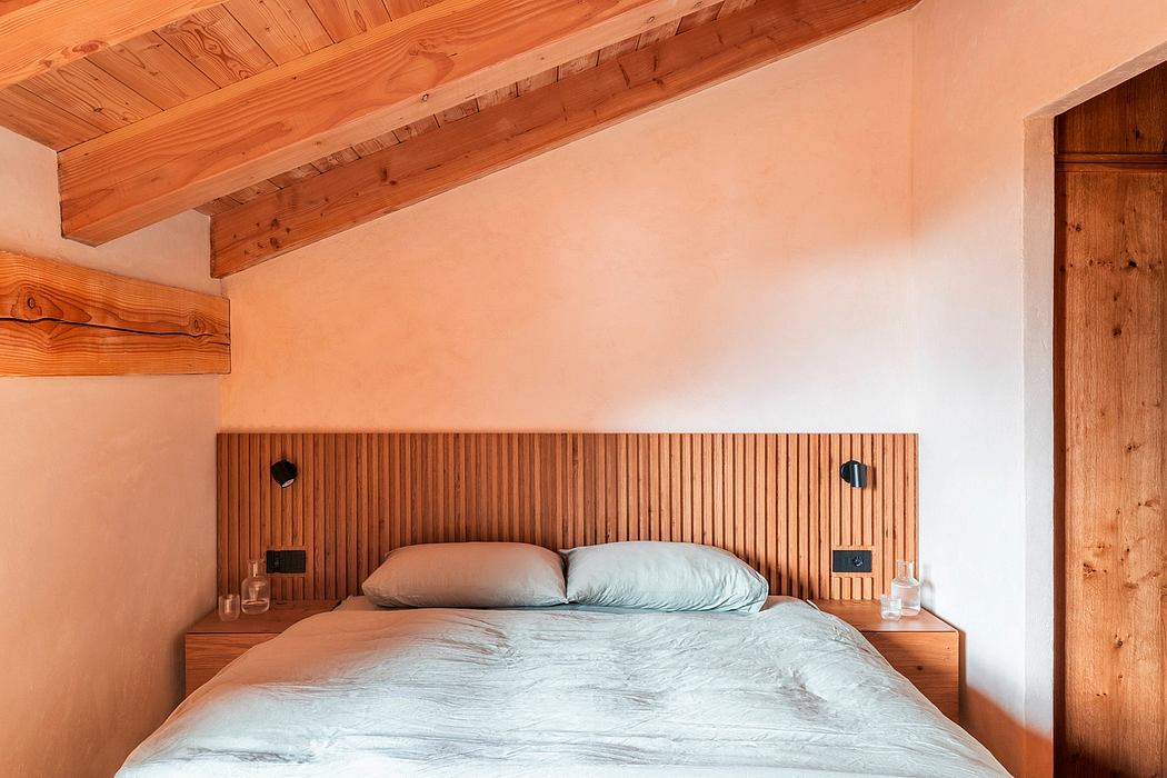 Rustic wooden beams and paneled headboard in cozy bedroom interior.