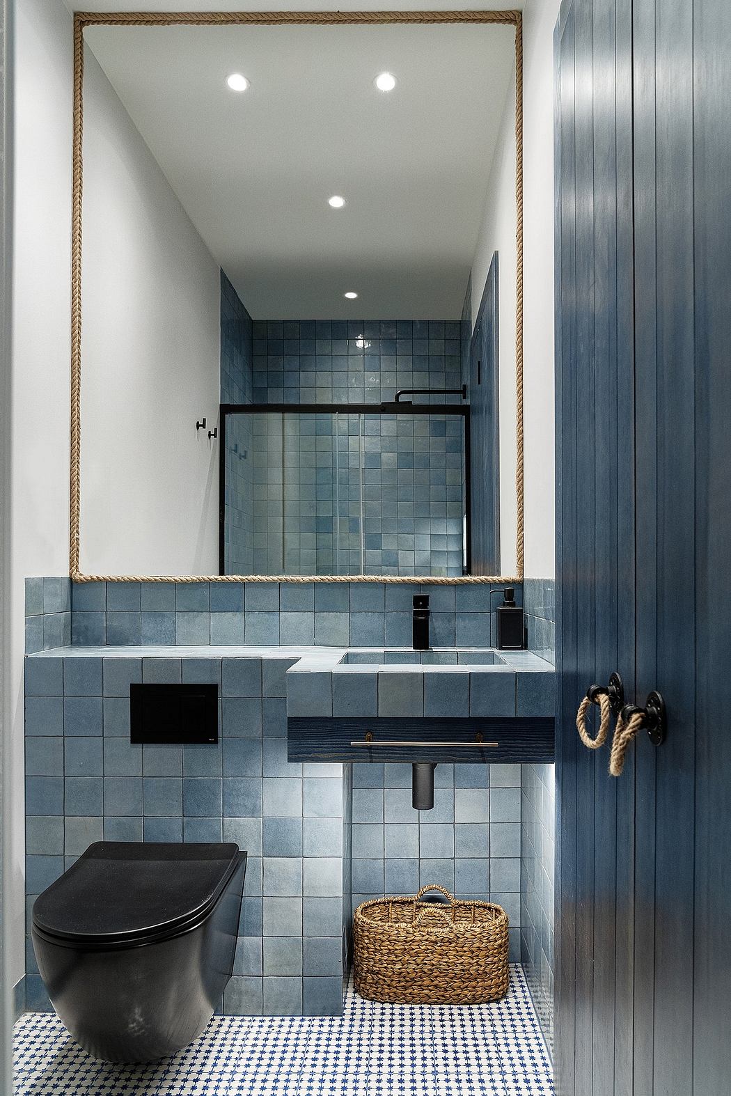 Modern bathroom interior with blue tiles and black fixtures.
