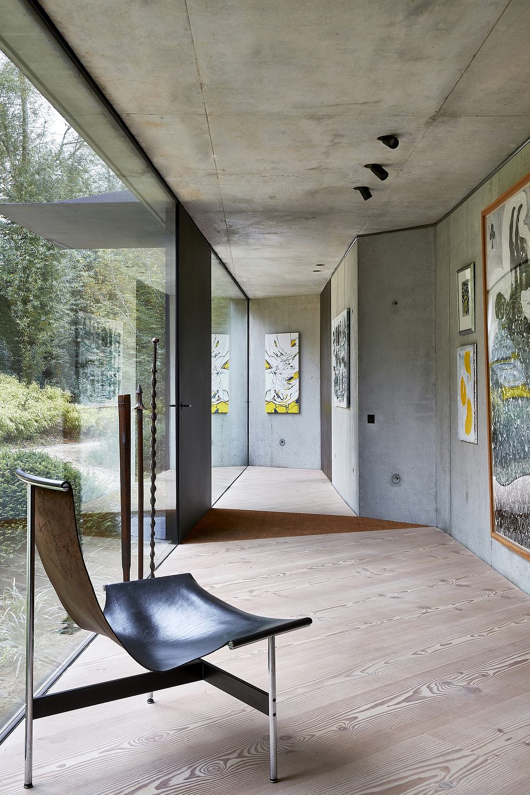 Minimalist corridor with concrete ceiling, wooden floor, and large windows.