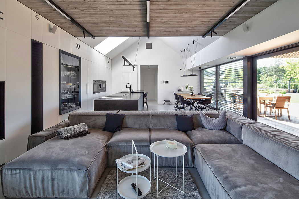 Modern living room with large sectional sofa and open-plan kitchen.