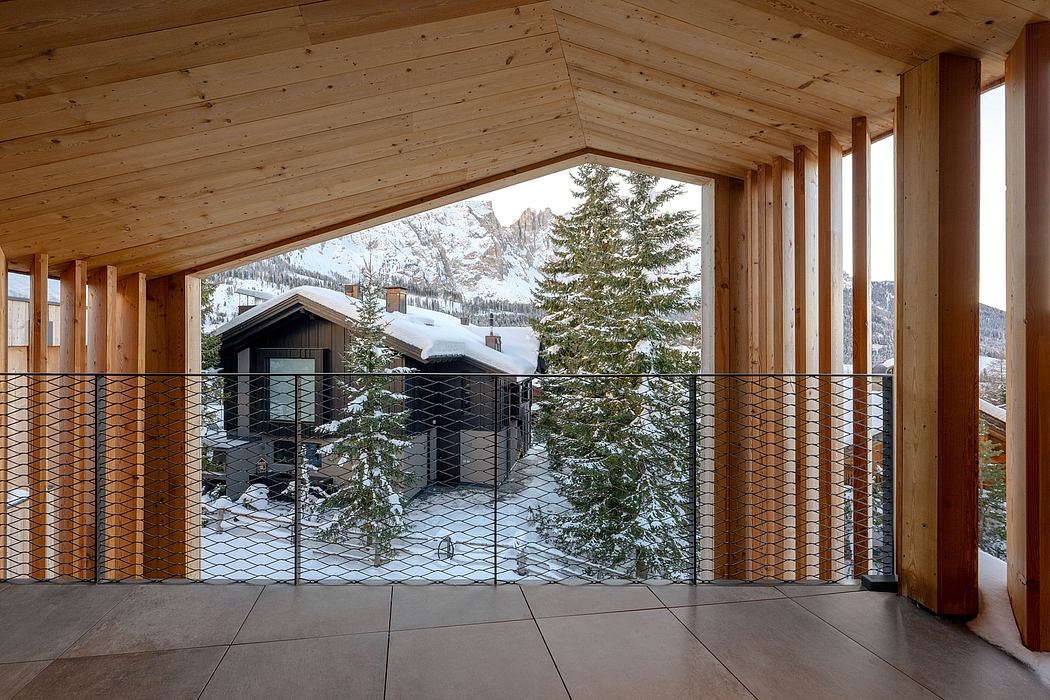 A cozy wooden cabin with a snow-covered landscape visible through the large windows.