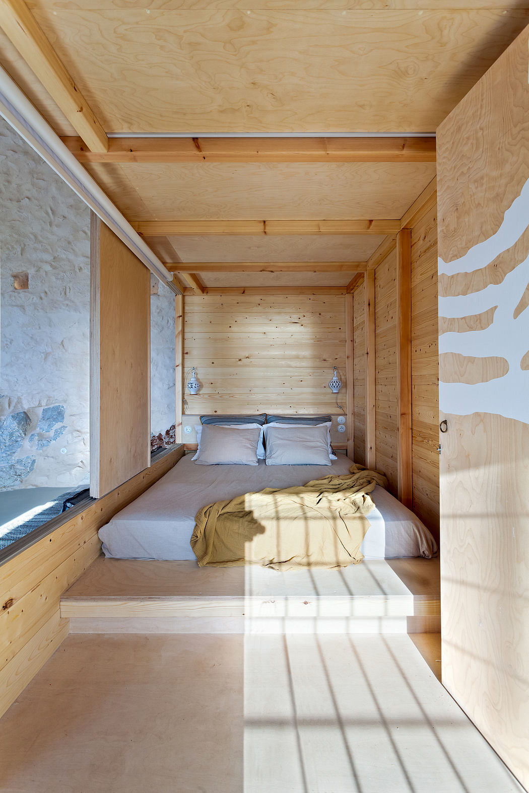 Cozy wooden cabin interior with minimalist decor and natural light from windows.