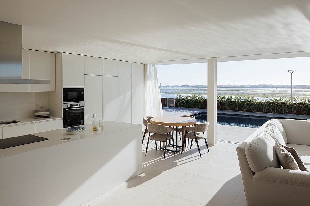 Modern, open-plan kitchen and dining area with floor-to-ceiling windows overlooking a pool.